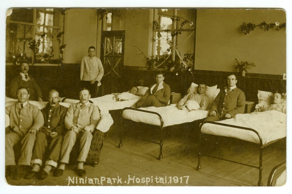 Photograph of patients on a ward at Ninian Park emergency war hospital in 1917. The ward is decorated for Christmas.
