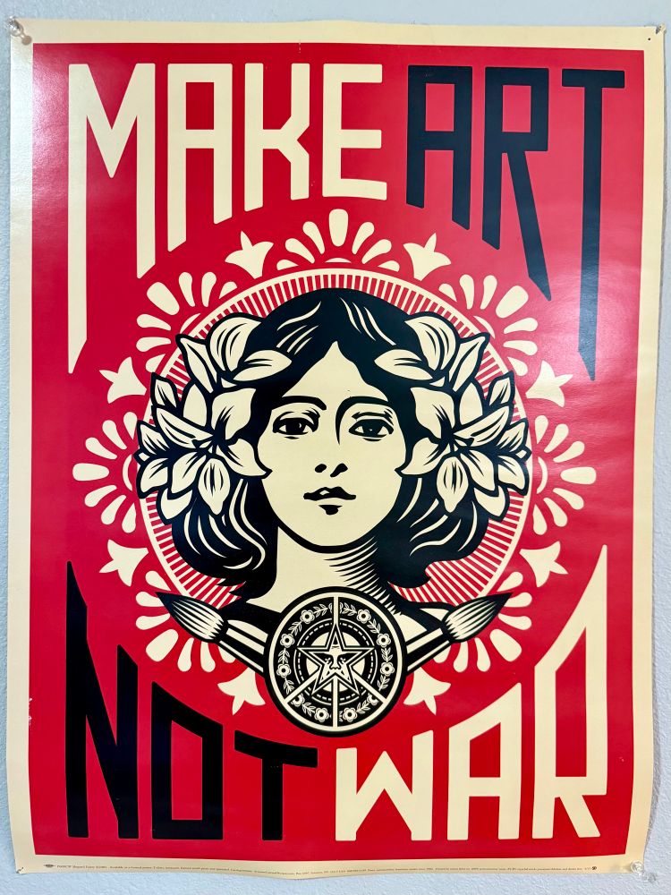 A graphic portrait of a woman with flowers in her hair appears on this iconic Shepard Fairey "Make Art Not War" poster. This artwork, created during the Iraq War, serves as a powerful statement promoting creativity and peace over destruction, drawing inspiration from the 1960s anti-war slogan "Make love, not war"
