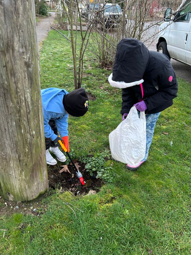 Two kids picking up neighborhood garbage. 