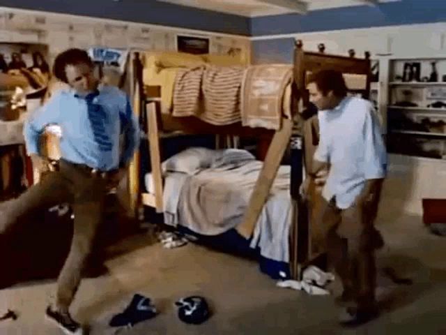 two men are standing next to each other in a messy room with a bunk bed .