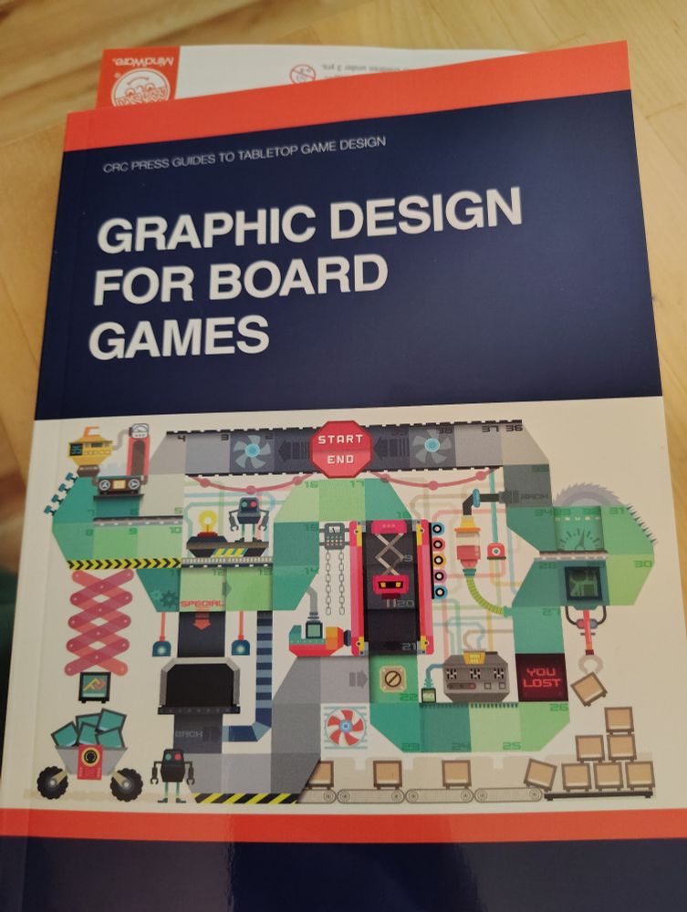 Cover of the book Graphic Design for Board Games that is blue with a board game design on it. Book by Daniel Solis printed by CRC Press