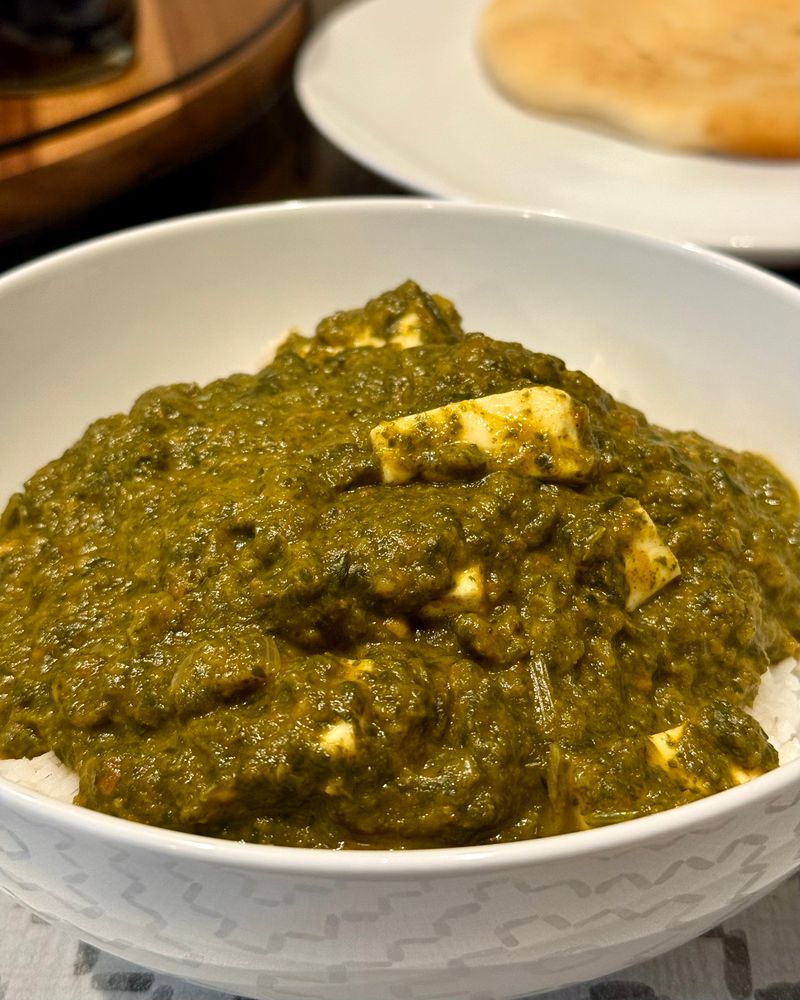 A bowl of palak paneer over basmati rice