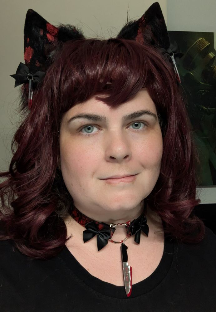 Selfie of Vivi in a red wig, blood splattered cat ears, and a choker with a bloody knife charm hanging from it
