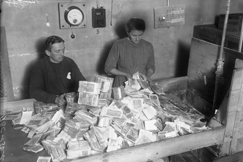 Photo of people counting massive stacks of worthless money in 1920s Germany 