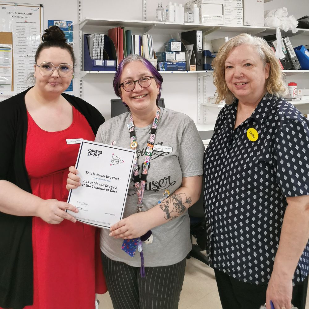 Three women smiling holding a certificate 