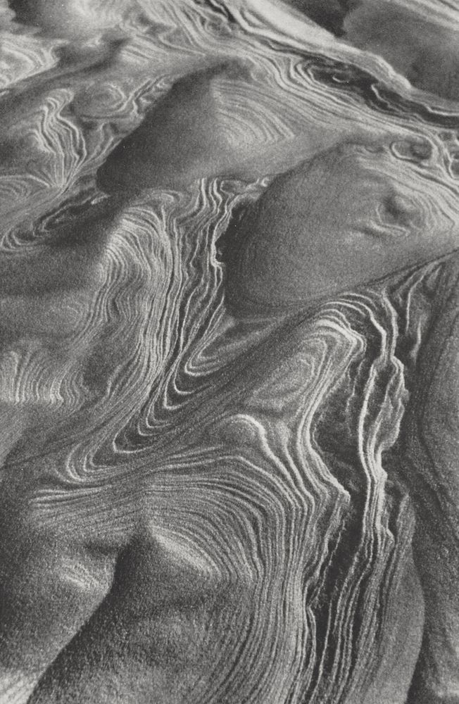 An archive photograph of waves of sand forming layered formations on a dune.
