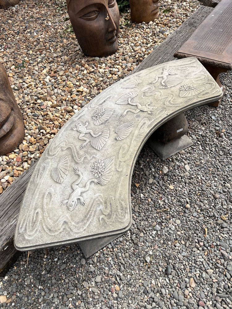 Same stone bench with engraved frogs but from a side angle