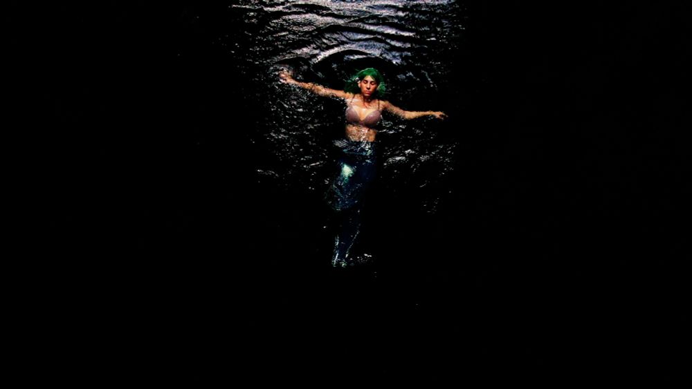 The Cenote Ring by Paola Estrella. Image shows person dressed as mermaid in water.