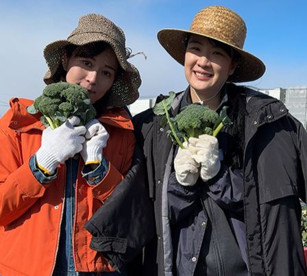 Manami and Emi show off the broccoli behind-the-scenes