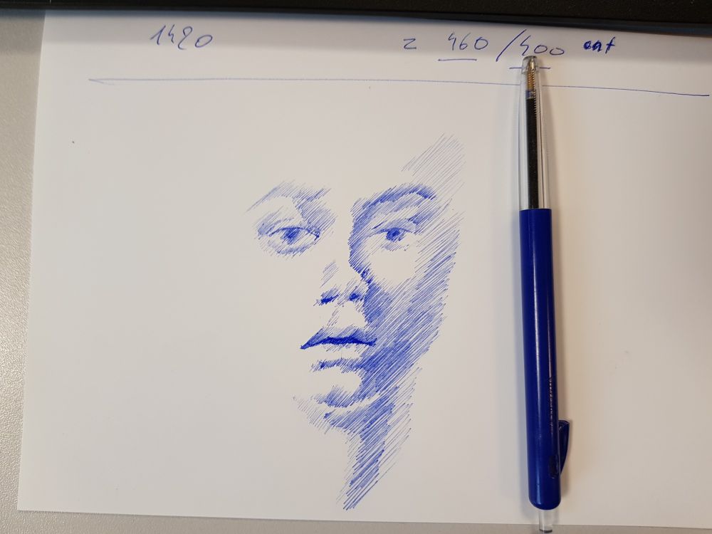 A delicate, minimalist portrait sketched in blue ballpoint pen. The image captures a side profile of a face, drawn with soft, overlapping diagonal lines that create depth and texture. The portrait is positioned slightly off-center on a white page, with a blue ballpoint pen resting beside it. The sketch focuses on the eyes, nose, and lips, conveying a contemplative, slightly melancholic expression through the careful, layered linework.R