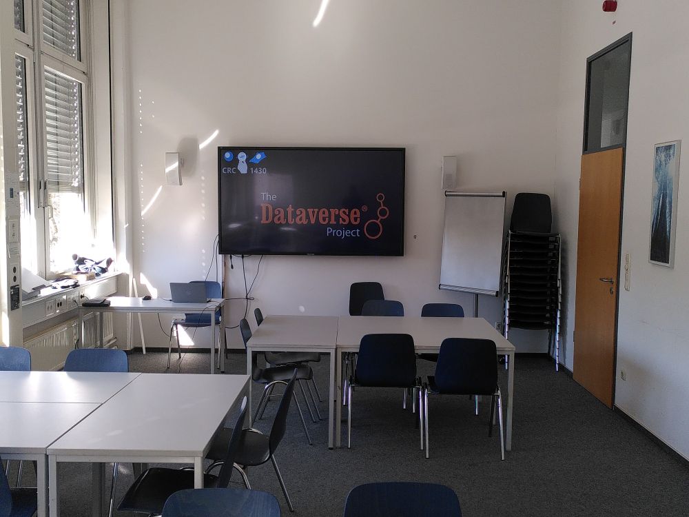 Seminar room with group tables and wall screen reading "Dataverse".