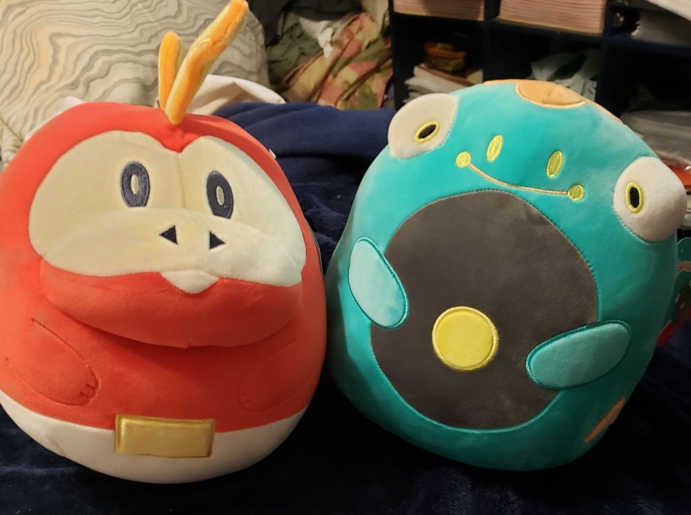 Squishmallow versions of Fuecoco and Bellibolt from Pokemon Scarlet & Violet