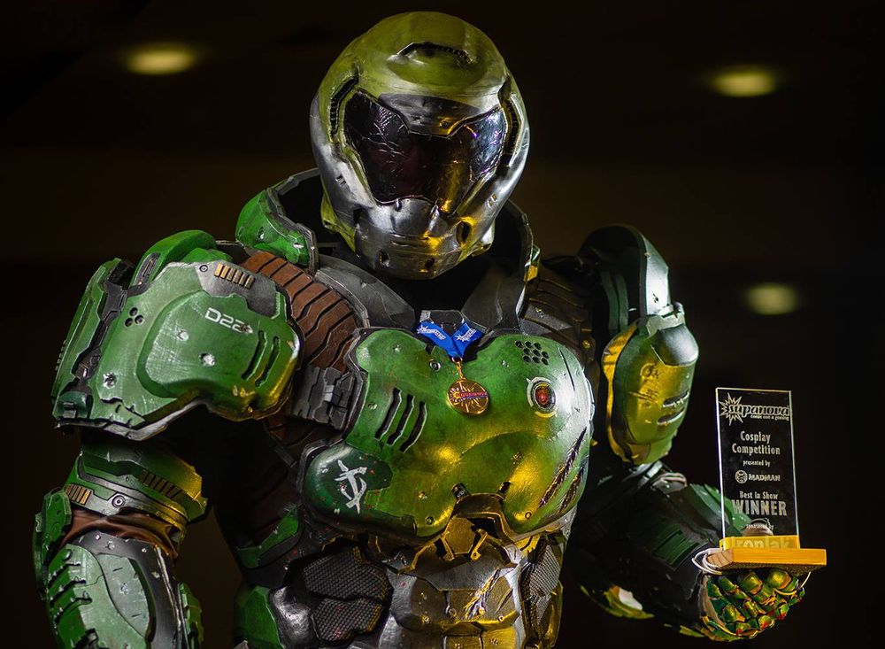 Une image d'un cosplay particulièrement réussi du Doom Guy, en armure verte futuriste avec un casque intégral