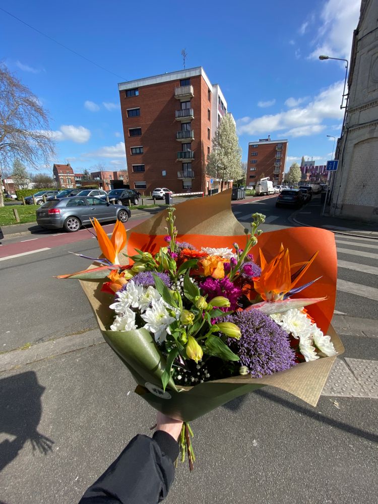 plan large d'un bouquet de fleur sous le soleil porté en extérieur dans la rue dans ma chambre, composé principalement de fleurs blanches, violettes et oranges