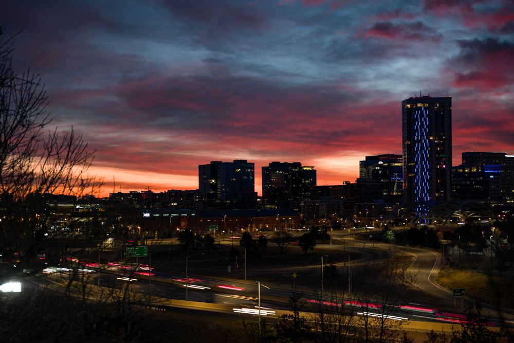 Commuters blur past lower downtown as the morning shifts from blue to gold light