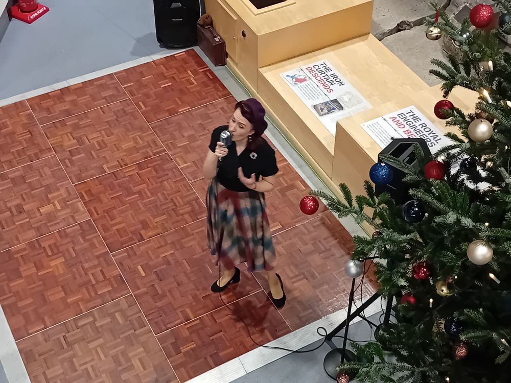 View from above of a 1940s style singer on a small wooden dancefloor.