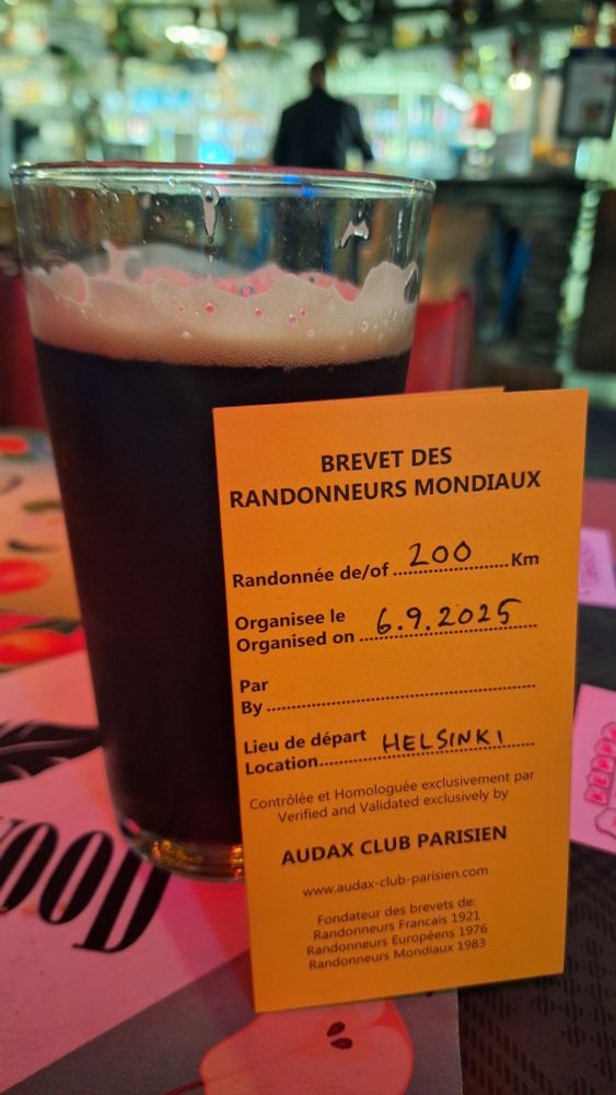 Lasillinen tummaa olutta ja ACP brevet-kortti