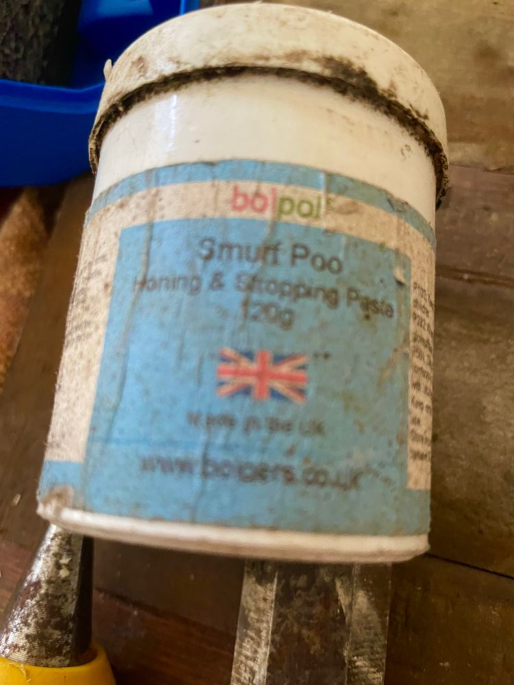 A small plastic pot with lid and a label that says “Smurf Poo” 