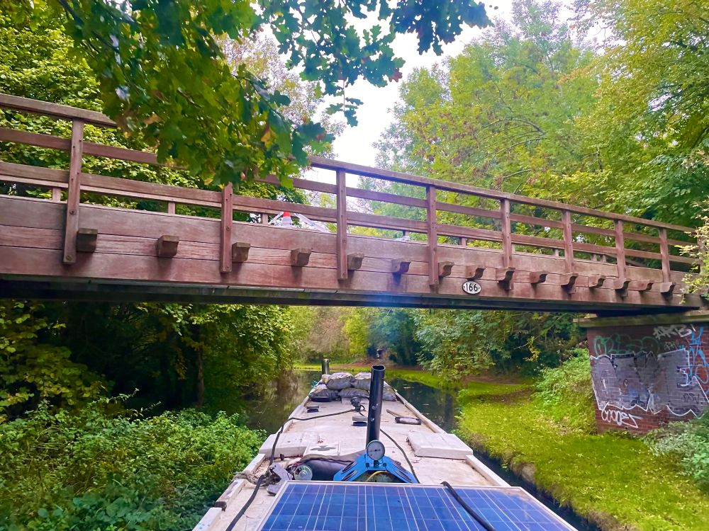 Narrowboat passing under a wooden bridge 