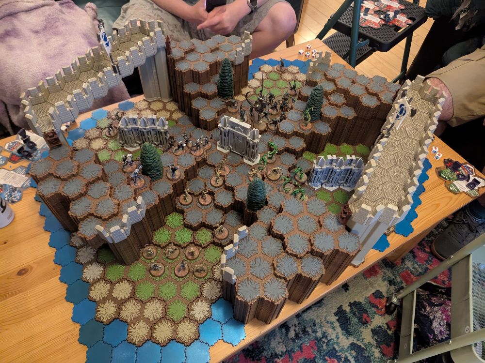 A photo of a heroscape map I built on my coffee table, covered in four armies of miniatures