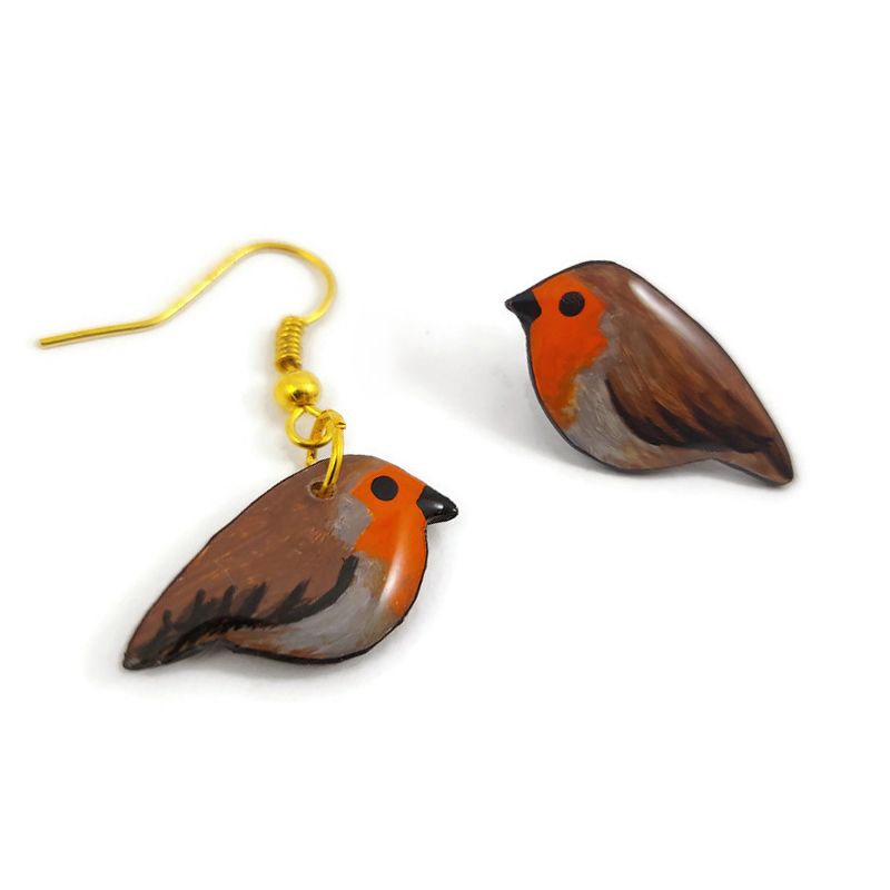 Paire de boucles d'oreilles asymétriques éco-responsables en forme de petits rouge-gorges.
Un côté pendant, l'autre puce d'oreille.
Les perles sont réalisées en CD recyclé, découpées et peintes à la main, puis recouvertes de résine époxy.