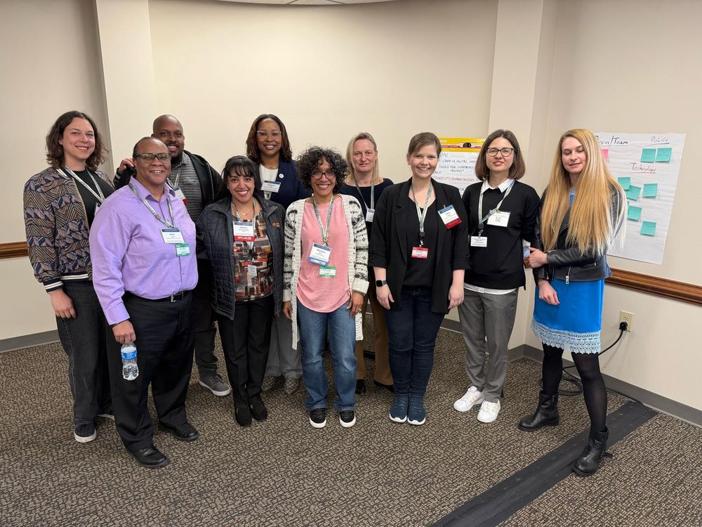 Ten people, one male and nine females, standing together in front of an easel. There are five American people and five German people.