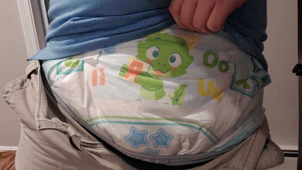 Showing off my big diaper that's extremely well-disguised by grown-up clothes 🤫

The diaper is a TryAgain by PretendAgain, featuring their adorable little green dragon Caden holding up a building block with some squiggly line on it. Also there's some stars under him that show I'm still dry (for now~)