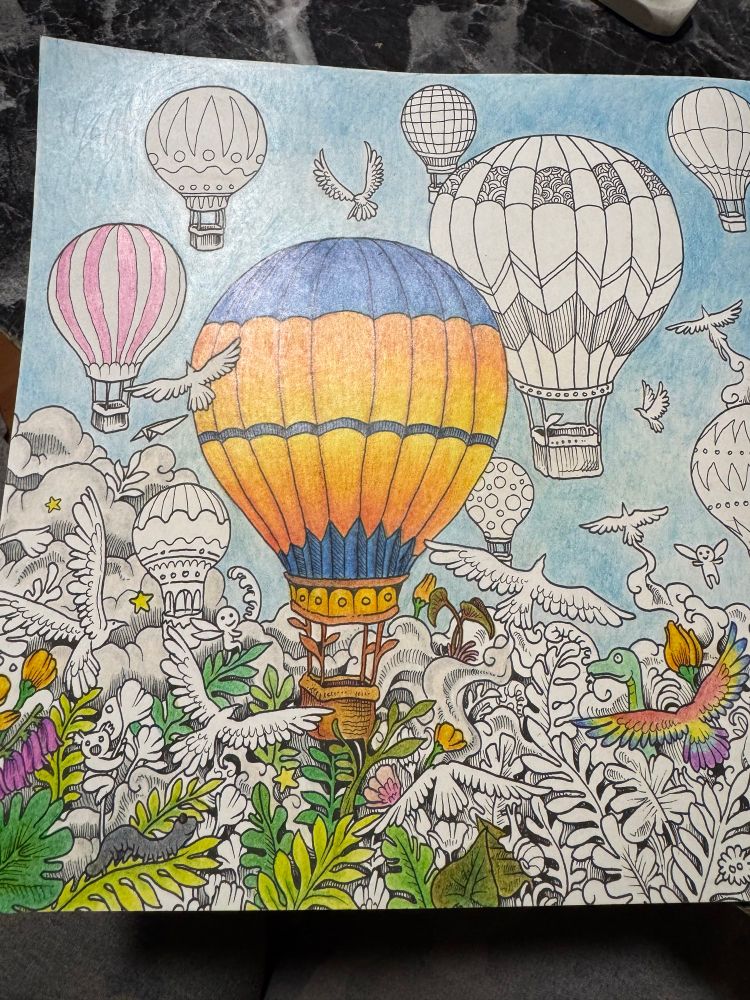 Hot air balloon coloring book page, work in progress. Main balloon in blues and orange, replicating a warm summer sky. 