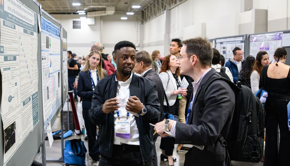 Two individuals discussing a poster presentation at the 2025 MIT Outstanding Poster Competition