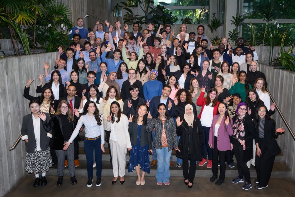 Large group of ARVO Foundation travel grant awardees standing on stair levels and waving