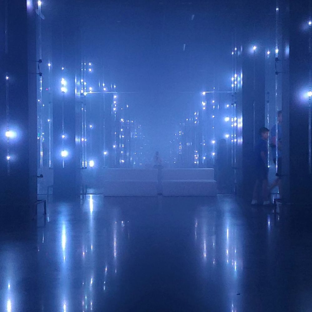A blue foggy room with sparkly lights and pillars.