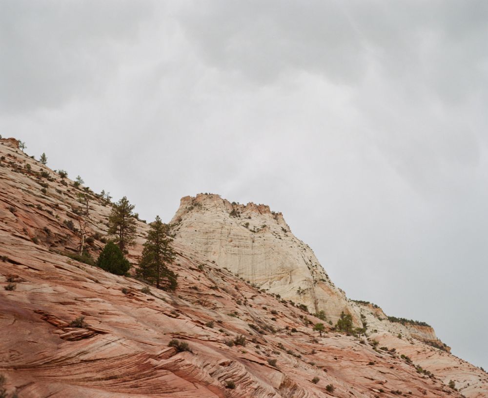 A photo of a large rock structure with a cloudy sky.