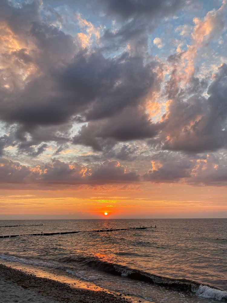 Ein Sonnenuntergang am Meer kurz bevor die Sonne untergeht. Mit vielen Wolken am Himmel.