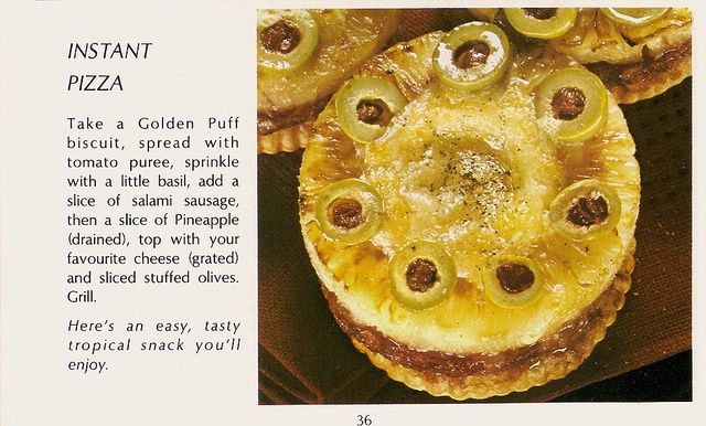 A photo of a grilled biscuit topped with tomato puree, salami, a pineapple ring, and stuffed olives.