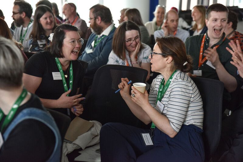 SCURL 20205 Delegates clearly enjoying themselves! Photo shows two people laughing and some smiling faces in the background.
