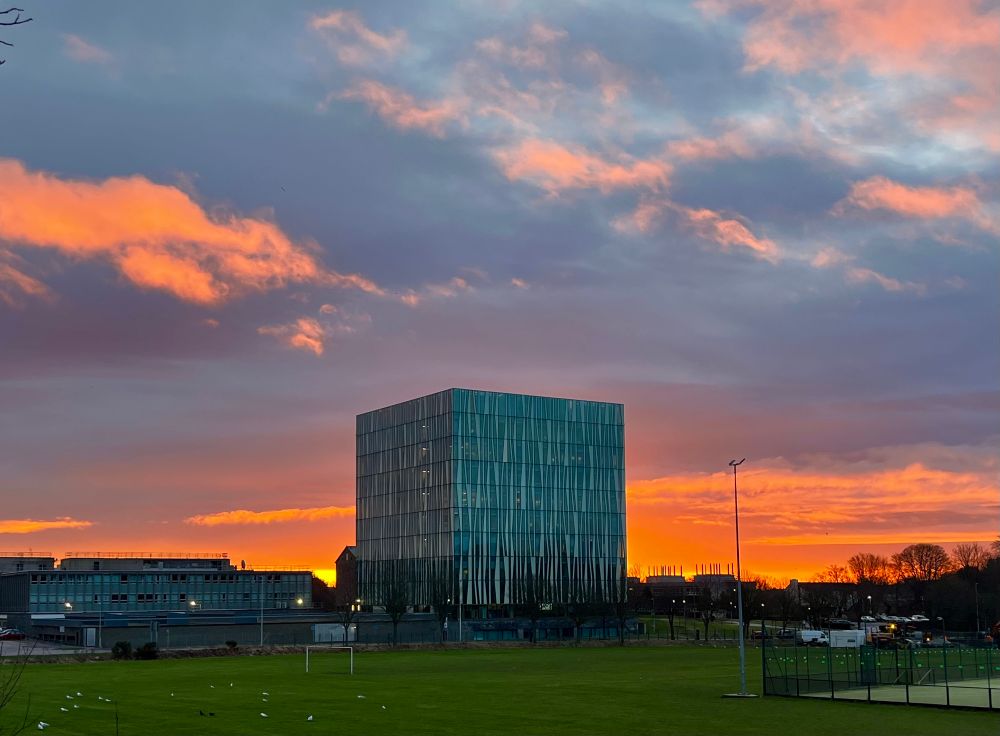 The Sir Duncan Rice Library in front of an orange and grey sky. 