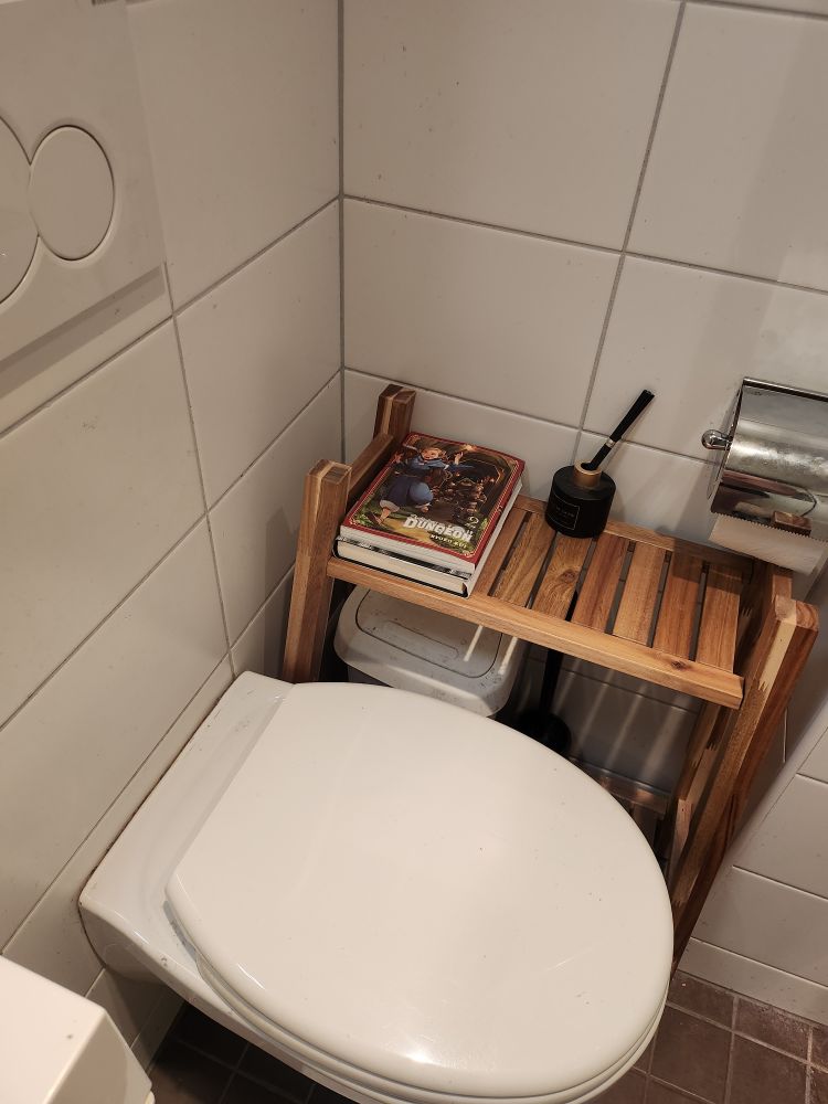 En do med en hylle ved siden av, det er en stabel med 2 bøker på den