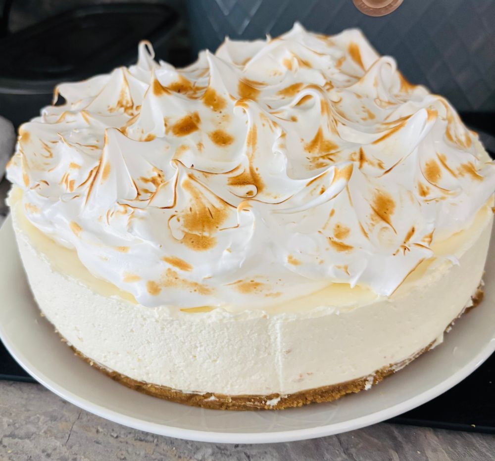 Picture of a deep lemon cheesecake with torched meringue topping. 