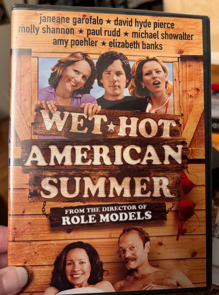 Image of the cover of the Wet Hot American Summer dvd. It lists a few of the stars including Jeane Garofalo, David Hyde pierce, Molly Shannon, Paul Rudd, Michael schowalter, Amy poehler, Elizabeth banks. And other whatnots I don't have the energy to describe. 