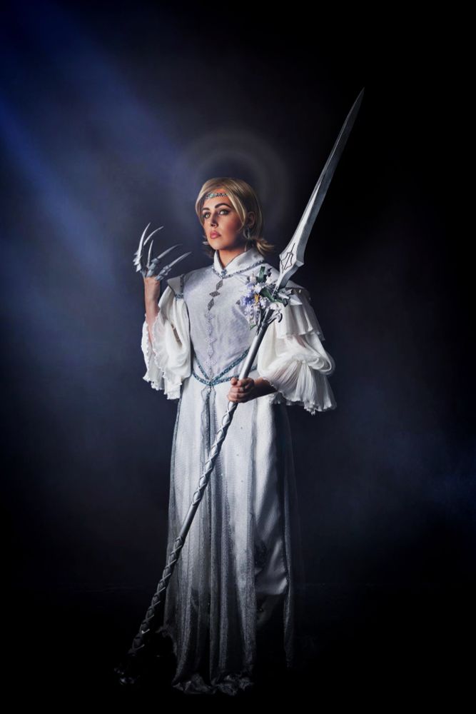An original cosplay of FFXVI’s Dion Lesage enshrouded in a pallor of light, holding his halberd that is adorned with a wild wyvern tail.