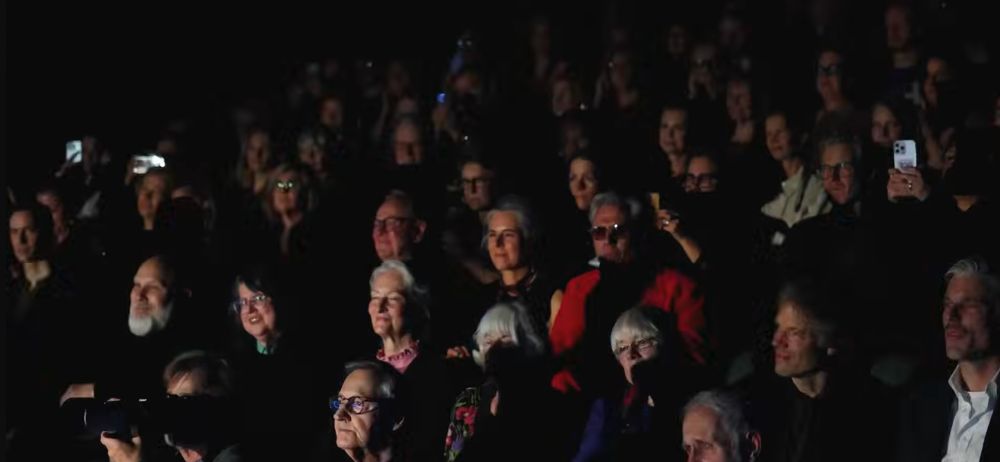 Reverse shot of mostly middle aged and up presumably Swedish people sitting in a theater watching vildhjarta play Meshuggah songs