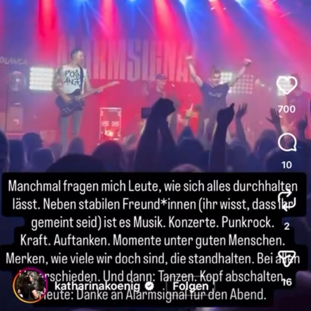 Standbild eines Insta-Reels von Katharina-König Preuß. Aufgenommen wurde es bei einem Konzert der Band ‚ALARMSIGNAL‘.

Während die Band den nächsten Song anspielen möchte, ist mitten auf der Bühne ein junger Mann zu sehen, der sich bereit für einen Sprung in die Menge macht. Er streckt die Arme in die Luft vor lauter Vorfreude.

Im unteren Bildrand hat sie noch folgenden Text hinzugefügt:

‚Manchmal fragen mich Leute, wie sich alles durchhalten lässt. Neben stabilen Freund*innen (ihr wisst, dass ihr gemeint seid) ist es Musik. Konzerte. Punkrock. Kraft. Auftanken. Momente unter guten Menschen. Merken, wie viele wir doch sind, die standhalten. Bei allen Unterschieden. Und dann: Tanzen. Kopf abschalten. Heute: Danke an Alarmsignal für den Abend.‘