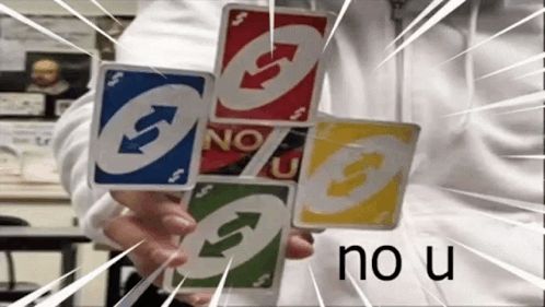 a person is holding four uno cards in their hand .