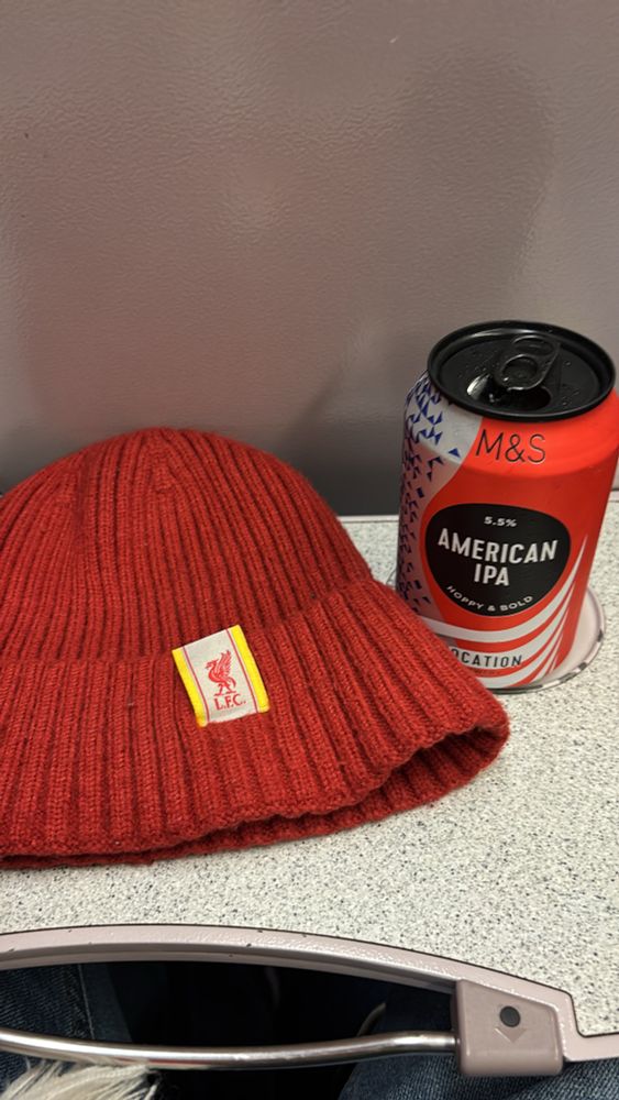 Liverpool hat and beer on a train