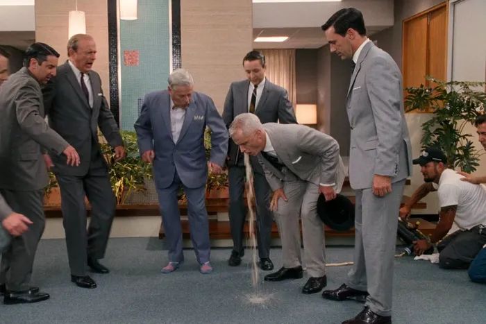 A scene from Mad Men where a crew member operating the vomit hose is inadvertently included.