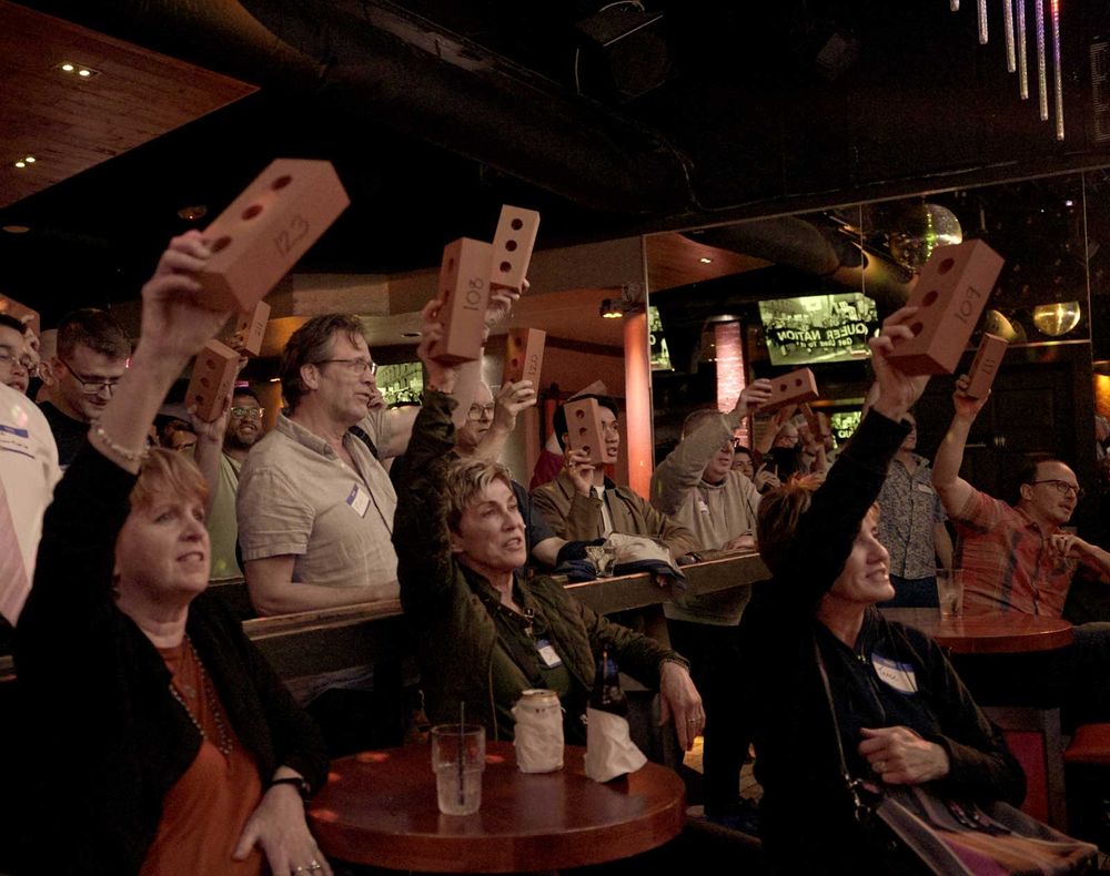 Stonewall Action launch attendees raising their bricks