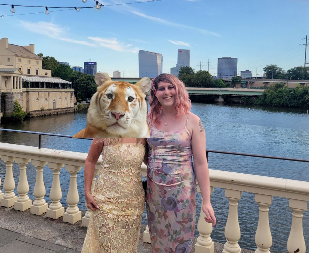 Two wedding guests in their dresses in front of the Schuylkill river