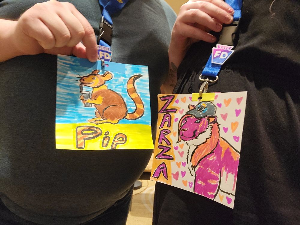 Marker-drawn badges of Pip the rat and Zarza the tiger on Furrydelphia lanyards