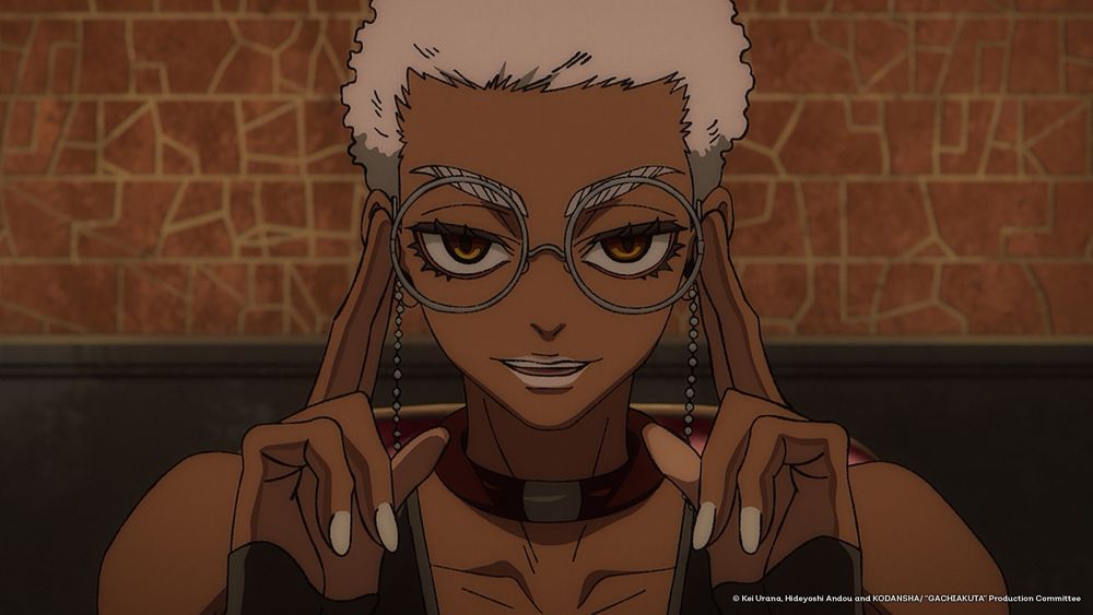 Cena colorida da personagem Semiu Grier, do anime Gachiakuta. Ela aparece sorrindo de forma confiante, olhando diretamente para a frente, com as mãos segurando os óculos redondos de armação fina, próximos às têmporas. Tem pele escura, cabelo curto e claro, sobrancelhas espessas e claras, e usa um colar largo com detalhe metálico. O fundo é composto por uma parede de tijolos em tons terrosos