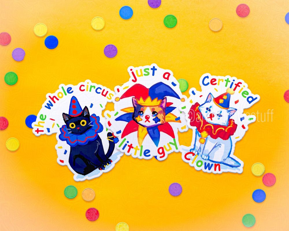 Three stickers with cats dressed up as clowns, the left is a black cat with the text 'the whole circus', the middle is a calico with the text 'just a little guy', the right one is a white cat with the text 'certified clown' 